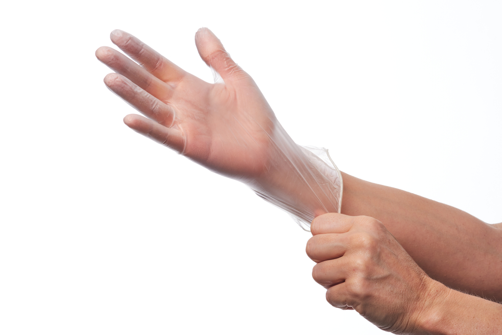 Female,Hands,Using,Vinyl,Gloves Clear Vinyl Food Service Disposable Gloves, Extra Large - Image 1